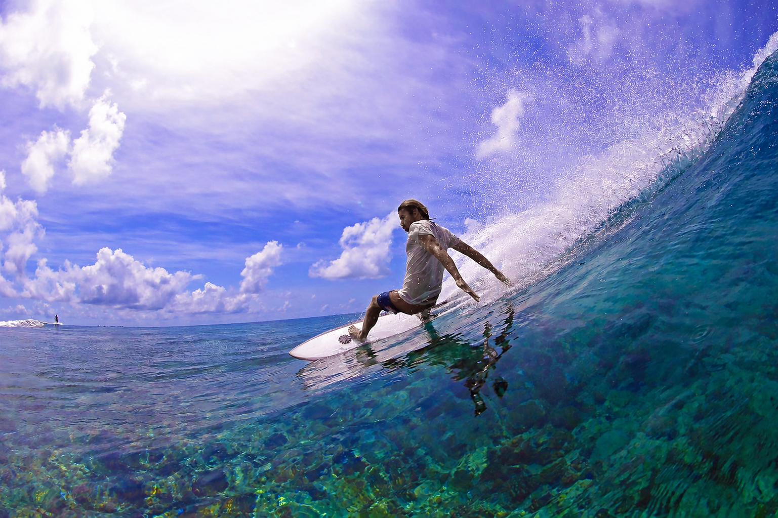 Surfer drawing a line across a clear tropical wave on a Gary McNeill Concepts board