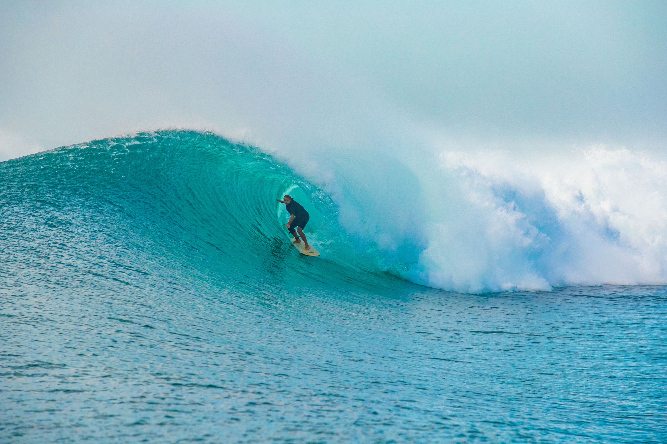 Surfer drawing a line through a powerful blue barrel
